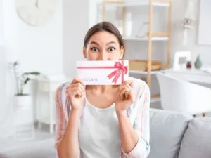GiftCert A happy lady holding a gift certificate